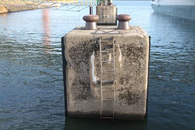 Close-up of water bottle on pier over lake