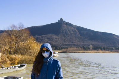 Mtkvari river and woman with face mask on the beach in mtskheta, georgia.