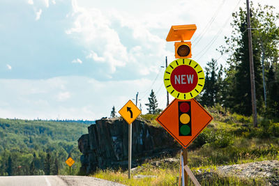 Information sign by road against sky