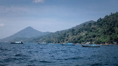 Scenic view of sea and mountains against sky