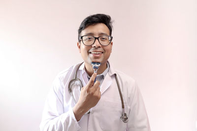 Mid adult man wearing eyeglasses against white background