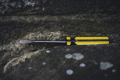 Close-up of screwdriver on rock