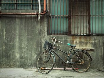 Old bicycle parked by house