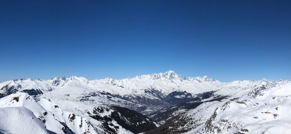 Scenic view of snowcapped mountains against clear blue sky