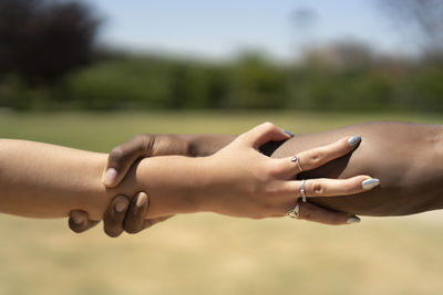United hands of colored man with white woman person