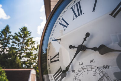 Close-up of clock against sky