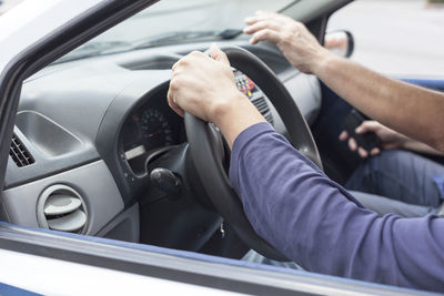 Cropped hands of men in car