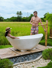 Side view of woman standing in bathtub