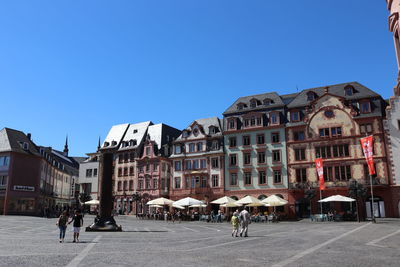 People walking on street by buildings in town