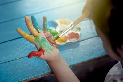 Cropped image of girl painting on hand