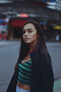 Portrait of confident teenage girl standing in city