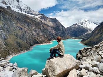 Man looking away while sitting on rocks