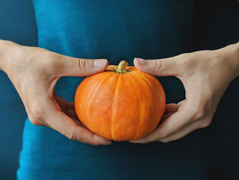 Midsection of person holding pumpkin
