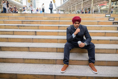 Full length of man sitting on staircase