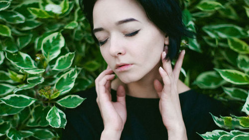 Close-up of young woman touching plants