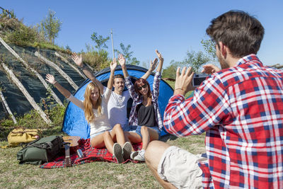 Group of friends on vacation takes photos at the campsite