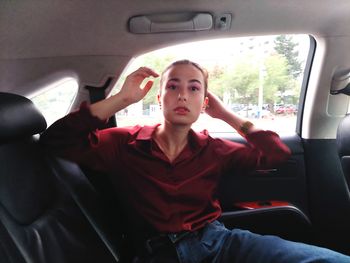 Portrait of young woman sitting in car