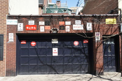 Various signs on brick wall during sunny day