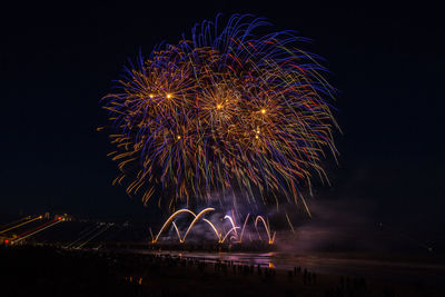 Low angle view of firework display at night