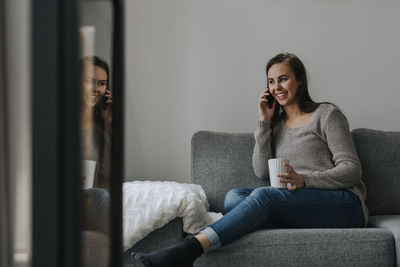 Young woman using mobile phone at home