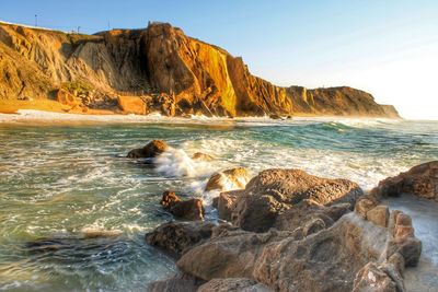 Scenic view of rocks in sea against sky