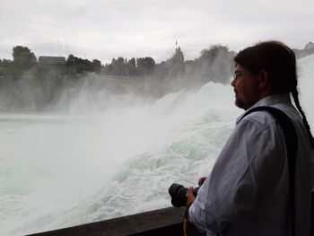 Rear view of man looking at waterfall