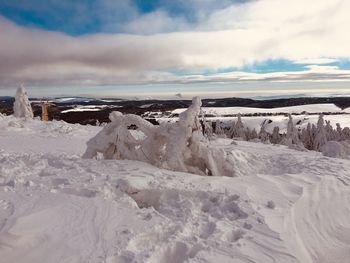 Snow covered land against sky