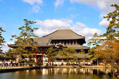 View of building by lake against sky