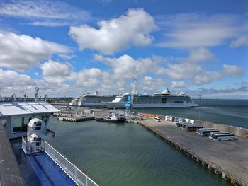 Boats moored at harbor against sky