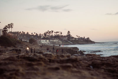 People at beach during sunset