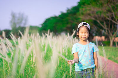 Portrait of cute girl standing on field