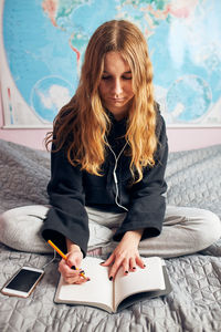 Student learning at home. young woman making notes, reading and learning from home during quarantine