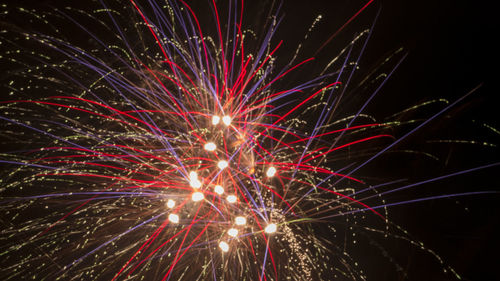 Low angle view of firework display at night