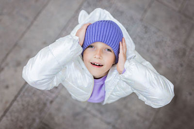 High angle portrait of girl wearing knit hat standing outdoors