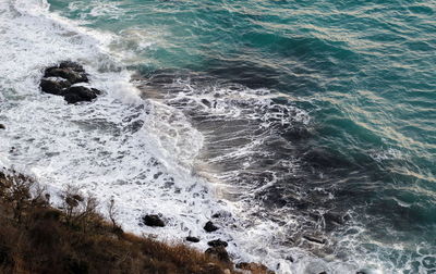 High angle view of waves splashing on rocks