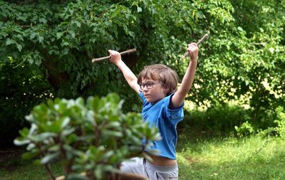 Full length of happy boy holding leaf in park