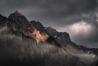 Low angle view of rocks on mountain against sky