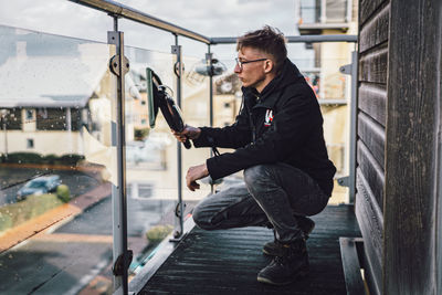 Side view of young man looking at city