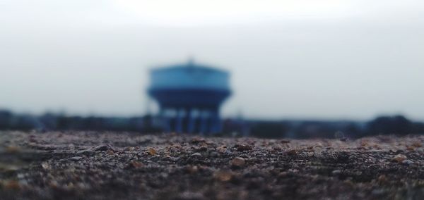 Tilt-shift image of building on field against sky