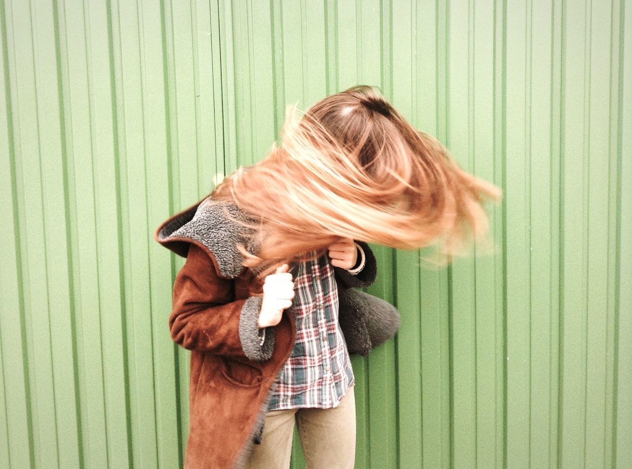 indoors, lifestyles, casual clothing, leisure activity, long hair, person, young adult, young women, wall - building feature, waist up, home interior, blond hair, side view, rear view, standing, sitting, obscured face