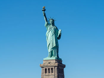 Low angle view of statue against blue sky