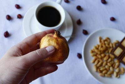 High angle view of hand holding coffee cup on table