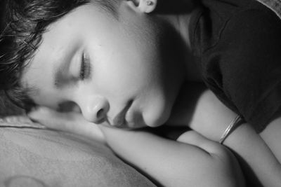 Close-up of boy sleeping on bed at home