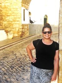 Portrait of young woman wearing sunglasses standing outdoors