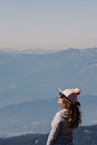 Rear view of woman wearing hat standing against sky