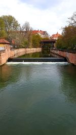 Bridge over river against buildings