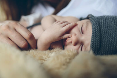 Close-up of baby sleeping on bed at home