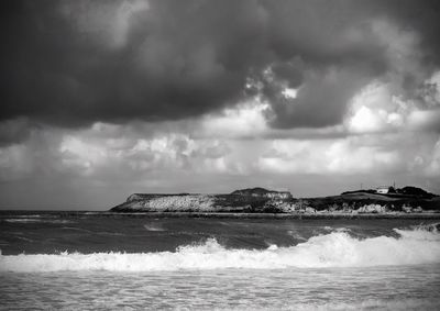 Scenic view of sea against storm clouds