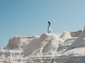 Young woman at white limestone beach sarakiniko on greek island milos
