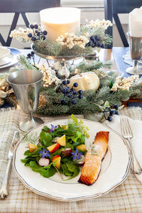 Organic greens salad with purple borage flowers, arugula, radish and salmon on a fine china dish